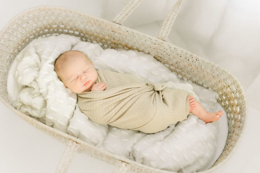 St Louis Missouri newborn photographer, Haven Hill Studios.  This is a newborn baby in a Moses basket in the studio. 