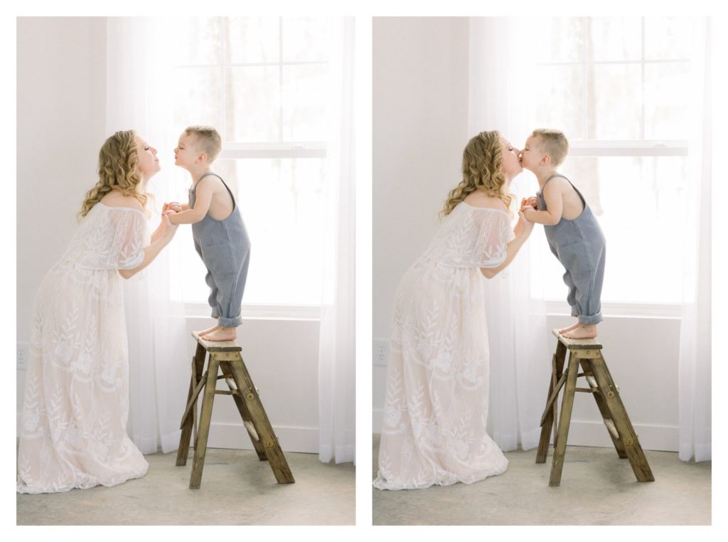 Photo of a toddler on a ladder in white photography studio kissing mom by Rolla photographer Haven Hill Studios. 